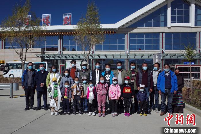 10位接受先心病治療的孩子及家長、工作人員等在日喀則和平機(jī)場合影?！〗w波 攝