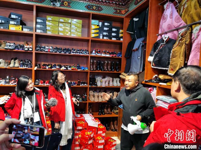 圖為中外媒體在玉樹州玉樹市甘達(dá)村采訪?！?zhí)砀?攝