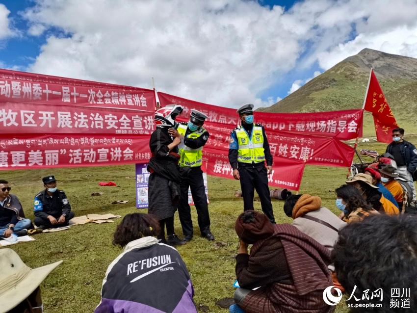 給牧民講如何佩戴安全頭盔。巴登攝