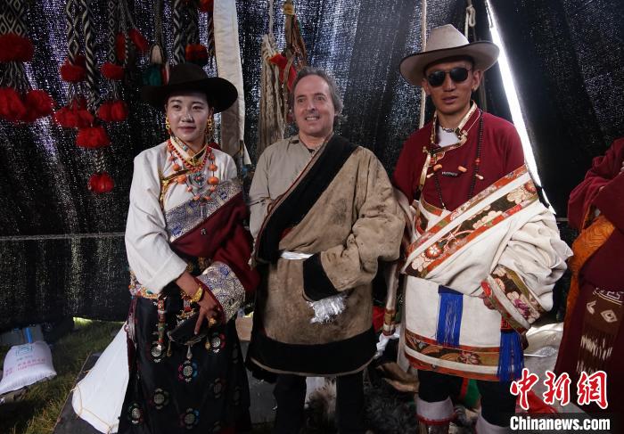 圖為一名外籍?dāng)z影師(中)身穿藏服和藏族民眾合影留念。　馬銘言 攝