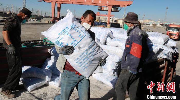 圖為裝卸人員將食鹽從汽車(chē)倒裝到火車(chē)上。　李生燕 攝
