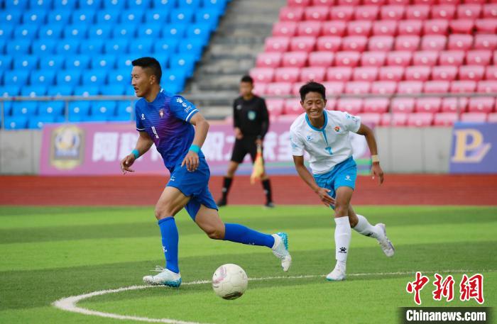 圖為班瑪隊(duì)(白)與達(dá)日隊(duì)隊(duì)員在球場(chǎng)感受快樂足球。　馬銘言 攝