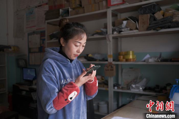 正在快遞站點(diǎn)內(nèi)忙碌的楊莉春?！『闻罾?攝