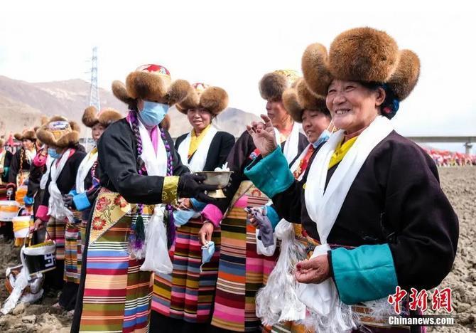 資料圖：西藏自治區(qū)拉薩市曲水縣才納鄉(xiāng)協(xié)榮村參加春耕儀式的村民互敬青稞酒。按照傳統(tǒng)，當(dāng)?shù)卮迕裆碇?jié)日盛裝，舉行隆重的儀式，祈福一年的豐收。<a target='_blank' ><p  align=