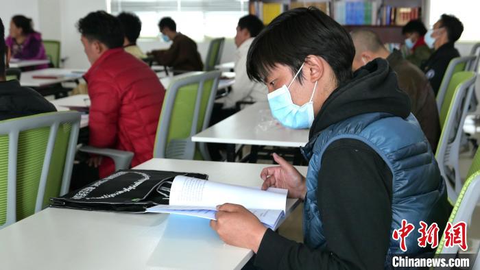 圖為正在閱讀“杰松達(dá)孜”藏歷法教材的學(xué)員?！≈x牧 攝