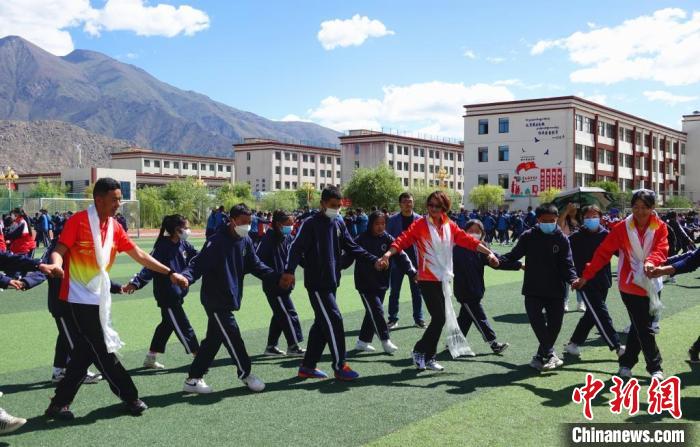 圖為世界冠軍與拉薩阿里地區(qū)高級中學(xué)學(xué)生一起跳鍋莊。　冉文娟 攝