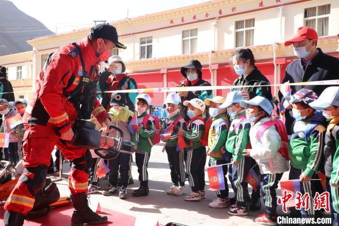 圖為消防指戰(zhàn)員為學(xué)生講解、演示先進(jìn)救援裝備?！≮w琳 攝