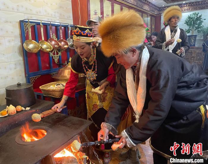 圖為人們?cè)诨鹕峡竟?jié)日美食“結(jié)達(dá)”?！∪轿木?攝