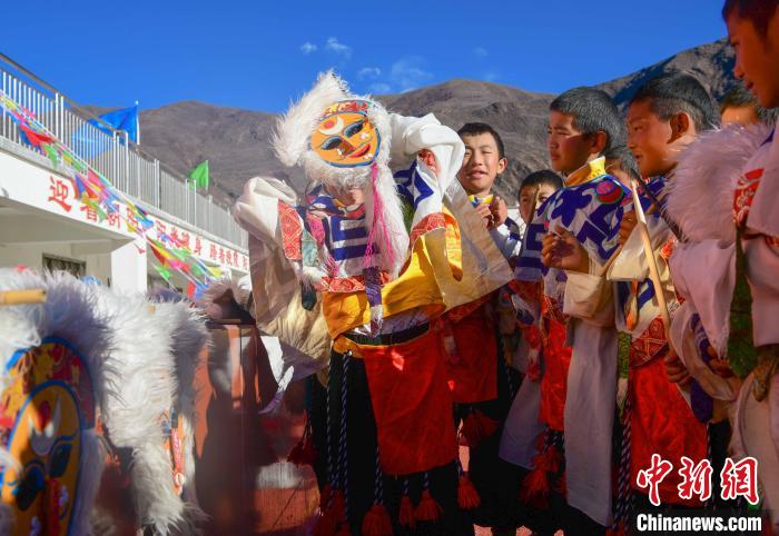 圖為加查縣安繞鎮(zhèn)小學(xué)學(xué)生在試穿藏戲面具?！∝暩聛硭?攝
