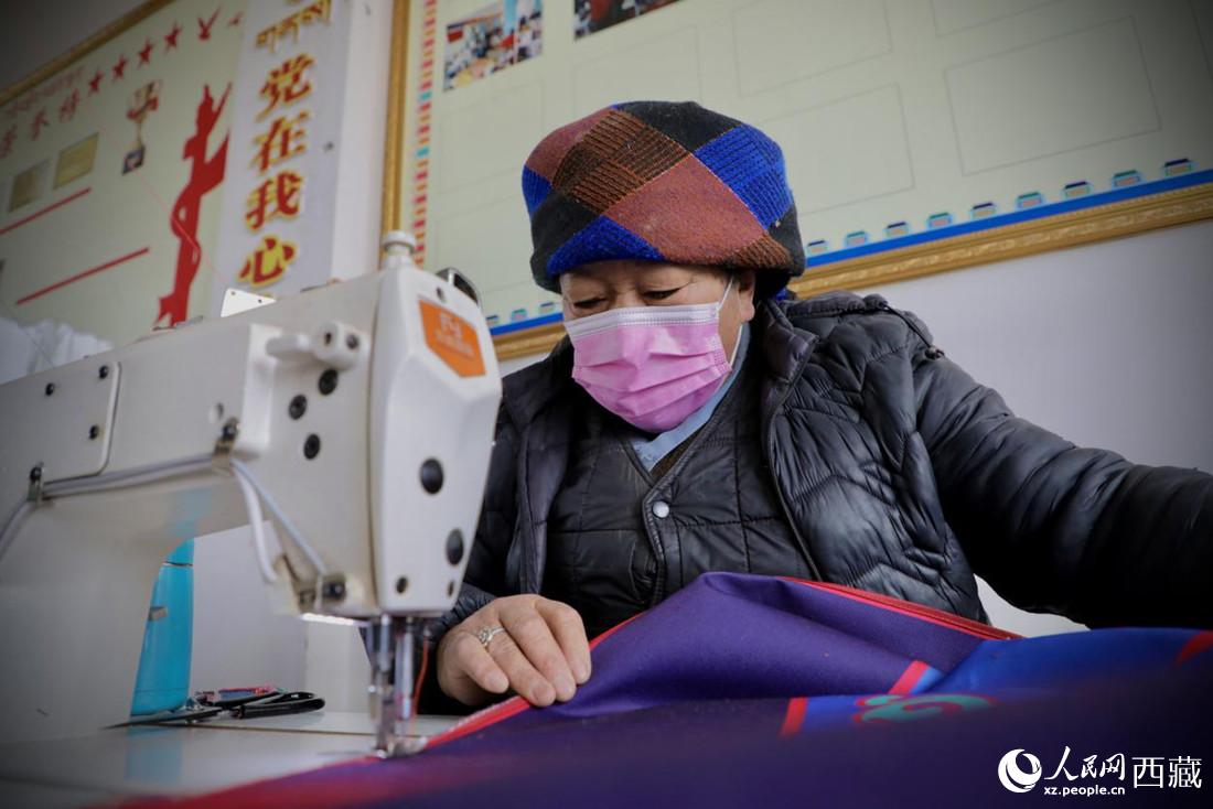 農(nóng)牧民專業(yè)合作社里的村民正在制作門簾。人民網(wǎng) 次仁羅布攝