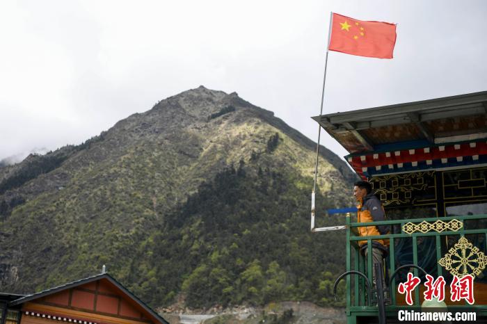 村民站在樓房上觀望。　楊華峰 攝