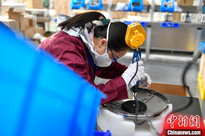 圖為工人正在組裝炊具?！∝暩聛硭?攝