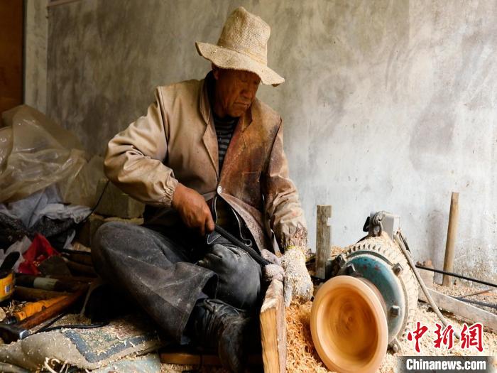 圖為手工藝人正在制作木碗。　 鄧海平 攝