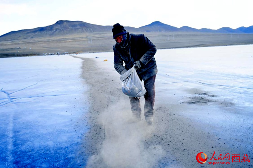 牧民在冰面上撒灰鋪成通道。人民網(wǎng) 李海霞攝