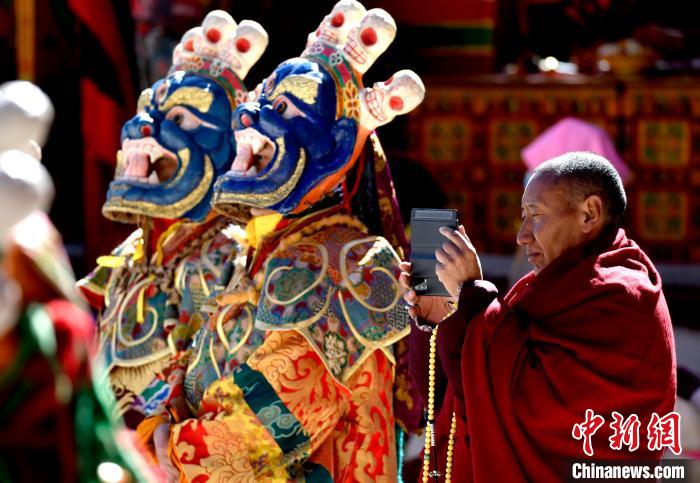 2月19日，正在拍攝跳神活動的僧人?！±盍?攝