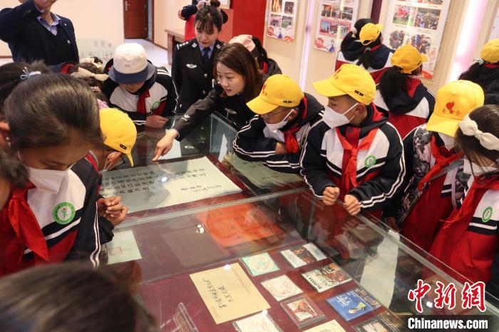 圖為亞東邊檢站民警為駐地小學生講解該站榮譽發(fā)展史。　胡利媛 攝