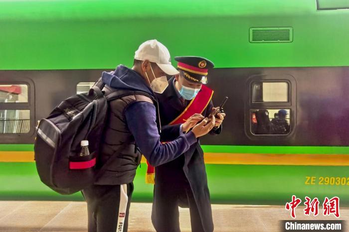 圖為日喀則火車站工作人員服務(wù)乘客?！《飞降?攝