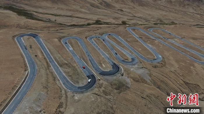 圖為騎手前往珠峰大本營途經(jīng)108道拐?！∮文恋厍蚬﹫D