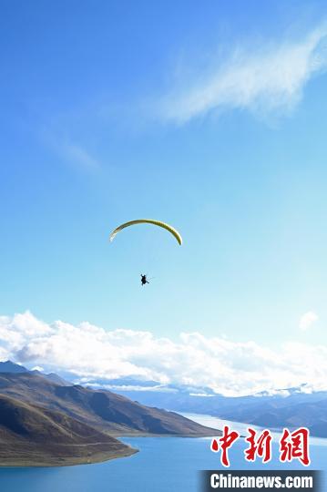 圖為在羊卓雍錯(cuò)，游客體驗(yàn)高空滑翔?！≮w朗 攝