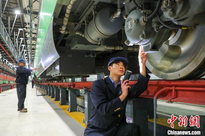 圖為工作人員檢查高原復(fù)興號(hào)?！≈軔傁?攝