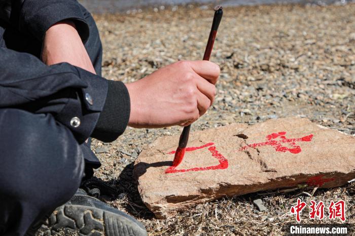 班公湖邊境派出所民警寫(xiě)下“中國(guó)”標(biāo)記。　龍小鳳 攝