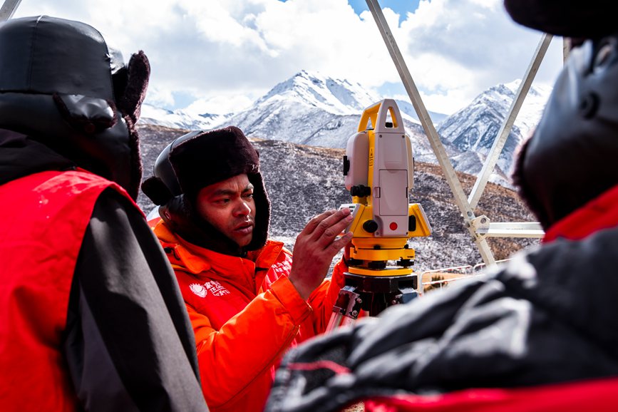 2023年11月30日，西藏自治區(qū)那曲市索縣榮布至丁青縣巴達(dá)35千伏線路工程負(fù)責(zé)人黃小洪（左二）現(xiàn)場(chǎng)開展線路弧測(cè)量教學(xué)。趙清鵬攝