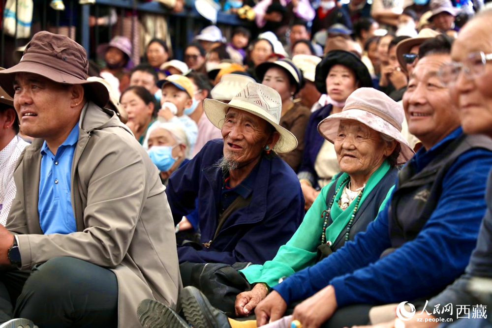 當(dāng)?shù)厝罕姾陀慰陀^看藏戲演出。