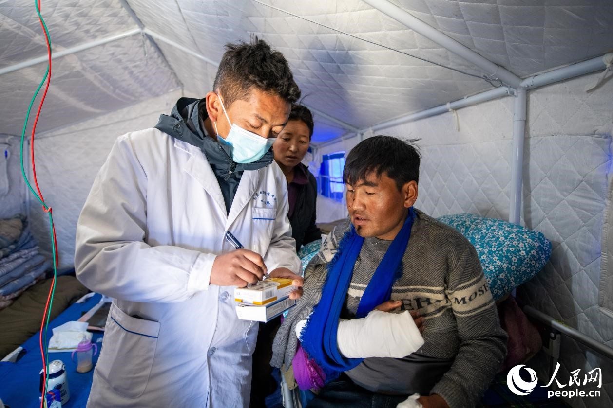 　醫(yī)生正在囑咐洛桑堅參如何用藥。人民網(wǎng)記者 翁奇羽攝