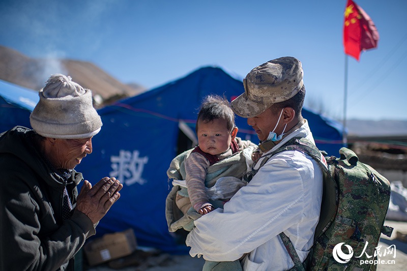 1月9日，在定日縣長所鄉(xiāng)古榮村安置點，受災(zāi)群眾感謝西藏軍區(qū)陸軍某部隊衛(wèi)生員的醫(yī)療救治。人民網(wǎng)記者 翁奇羽攝